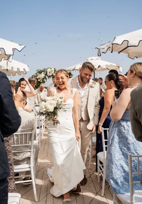 Bride and groom walking joyfully through confetti after their ceremony at Hospes Maricel & Spa.
