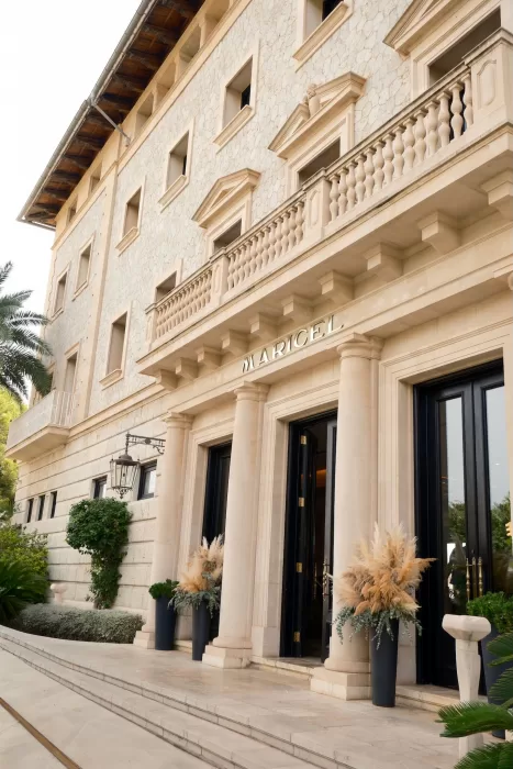 Grand stone entrance of Hospes Maricel & Spa framed by classic columns and greenery.