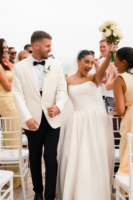 Bride and groom celebrate joyfully after their seaside ceremony at Hospes Maricel & Spa.