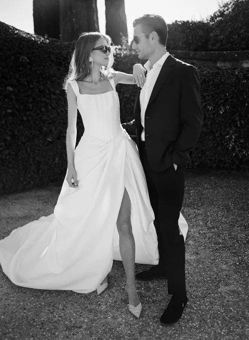 Black and white photo of bride and groom in elegant wedding attire, sharing a cinematic moment at Il Borro.