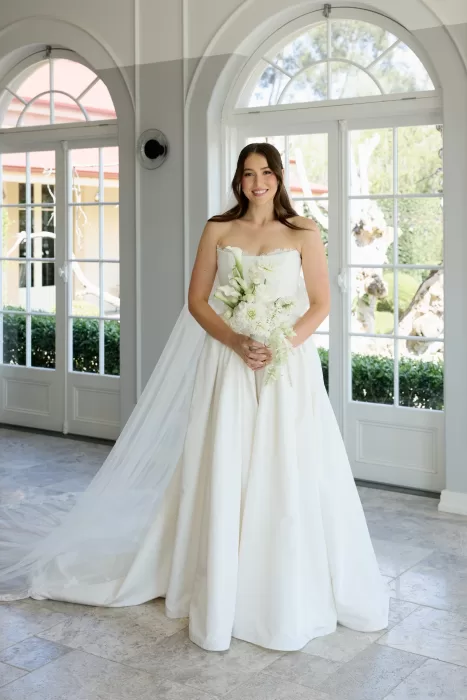 Bride in strapless gown holding white bouquet inside the elegant Le Mas Barossa villa.