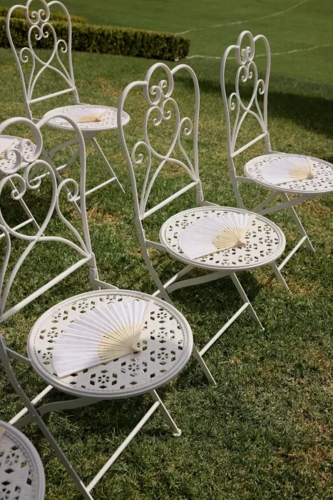 Elegant white ceremony chairs with hand fans arranged on the lawn at Le Mas Barossa.