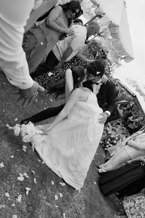 Bride and groom sharing a joyful kiss surrounded by guests at their outdoor ceremony at Le Mas Barossa.