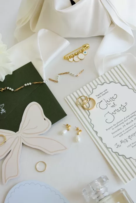 Wedding invitation suite with gold jewelry and silk details photographed at Le Mas Barossa.