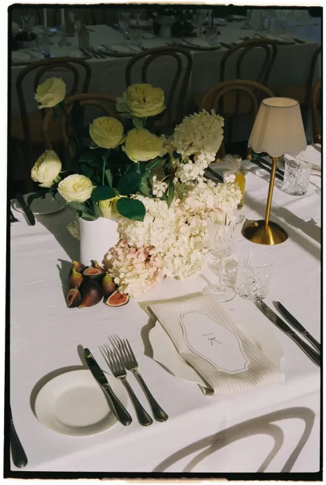 Elegant white wedding table at Le Mas Barossa with cream roses, figs, and crystal glassware.
