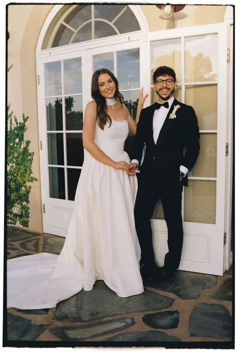 Newlyweds standing hand in hand by the villa doors at Le Mas Barossa.
