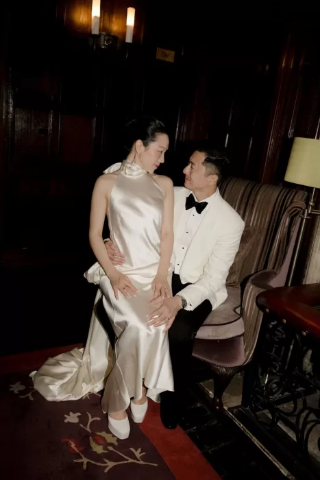 The couple share an intimate moment indoors at Manor House, the bride wearing a silk halter evening gown.