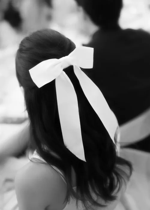 Elegant white bow tied in the bride’s hair during a modern wedding at Neuendorf House.