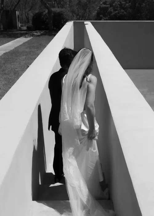Bride and groom walking together through the angular corridors of Neuendorf House.