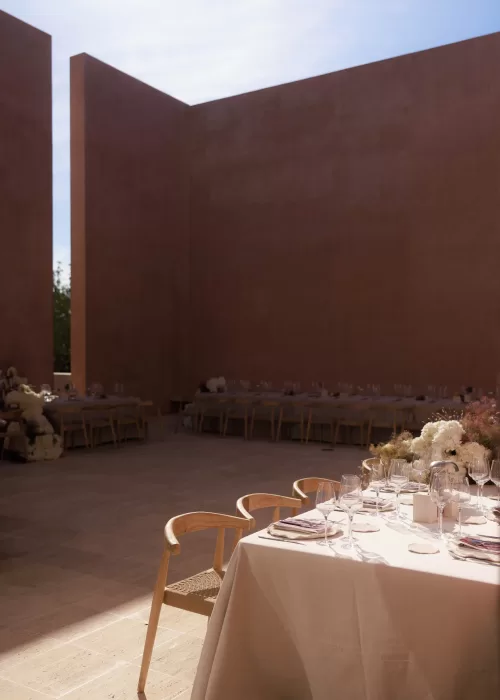 Minimalist courtyard reception setup surrounded by warm terracotta walls at Neuendorf House.