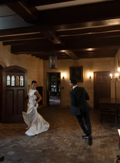 Newlyweds laughing and dancing together inside The Plummer House’s grand hall.