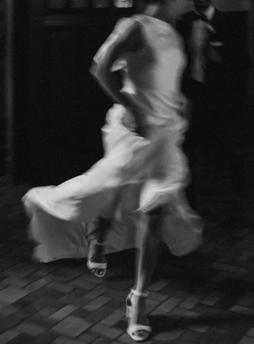 Artistic black and white shot of the bride running joyfully through The Plummer House hall.