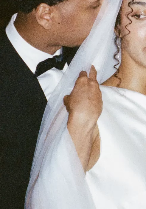 Soft film image of the groom kissing the bride’s shoulder beneath her veil at The Plummer House.