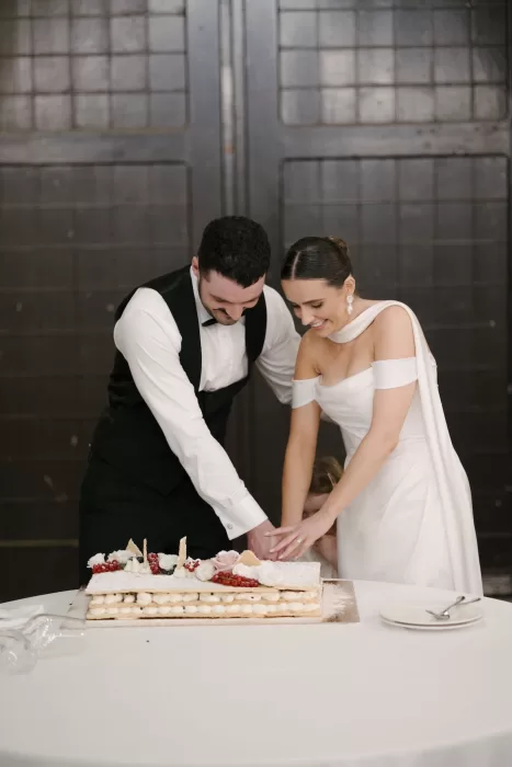 Bride and groom laughing as they cut their layered wedding cake at Quercia al Poggio.