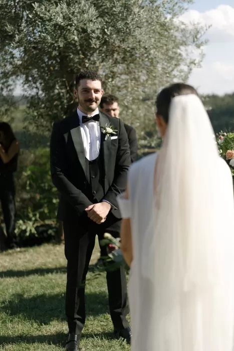Groom smiling as he watches his bride approach during the ceremony at Quercia al Poggio
