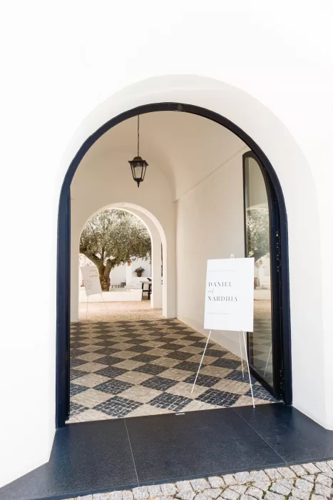 Elegant arched entrance at Quinta Dos Santos with minimalist wedding signage and tiled flooring.