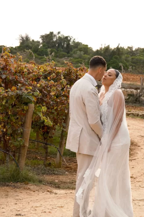 Bride and groom share an intimate kiss among the vineyard rows at Quinta Dos Santos, surrounded by autumn foliage.