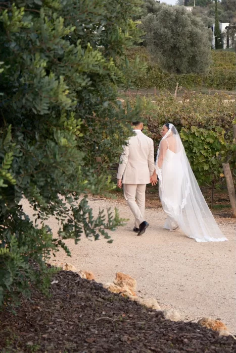 Bride and groom walk hand in hand through the peaceful vineyard paths at Quinta Dos Santos.