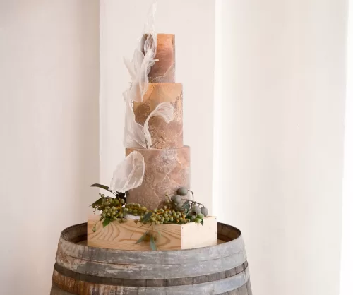 Textured terracotta-inspired wedding cake displayed on a wine barrel at Quinta Dos Santos.