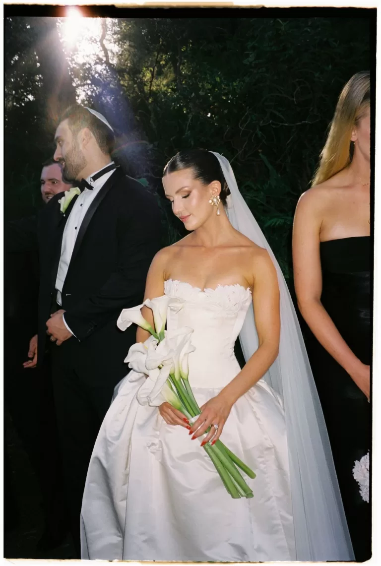 Bride holding white calla lily bouquet during ceremony at Sergeants Mess.