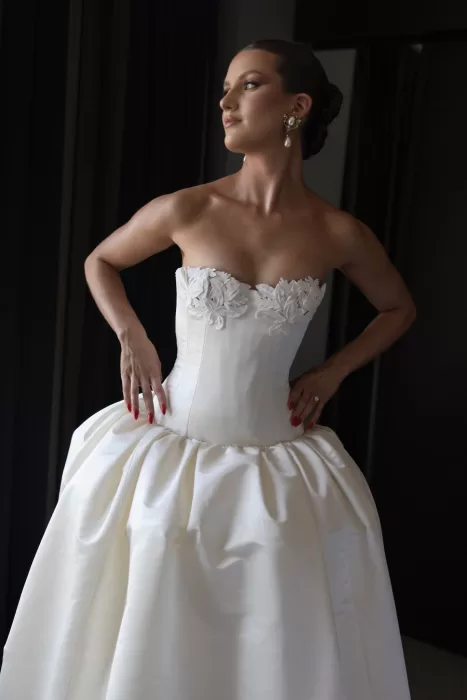 Bride in strapless gown with floral detailing posing by window light at Sergeants Mess.