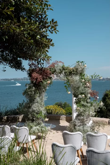 Floral arch overlooking the harbor set for a Sergeants Mess outdoor wedding ceremony.