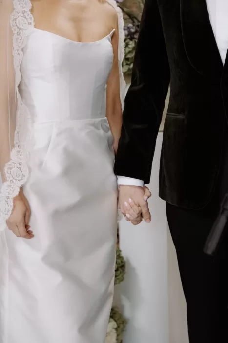 Close-up of the bride and groom holding hands during their ceremony at This Must Be The Place.