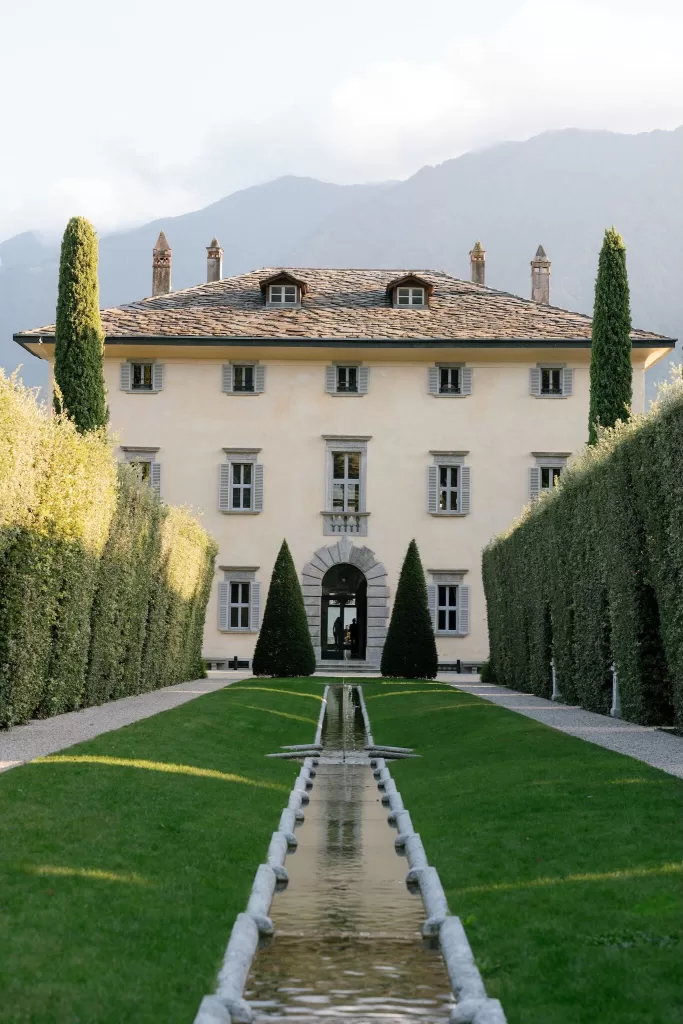 Manicured garden pathway with reflective water feature leading to Villa Balbiano.