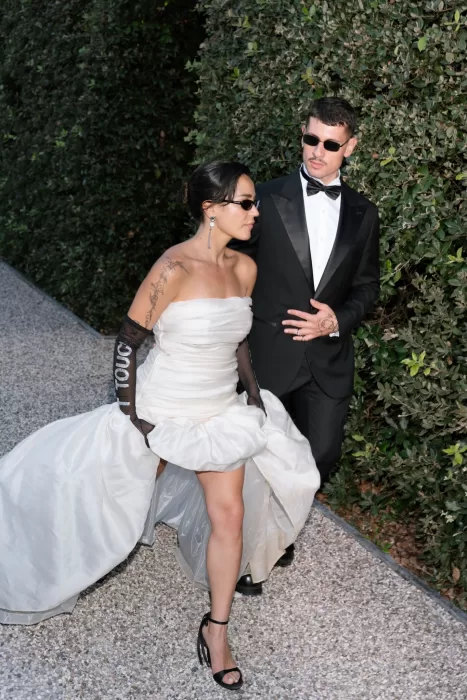 Bride and groom walking along a garden path in elegant attire at Villa Balbiano.