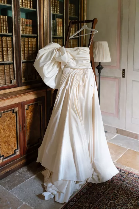 Couture wedding gown with voluminous bow displayed in Villa Balbiano’s historic library.
