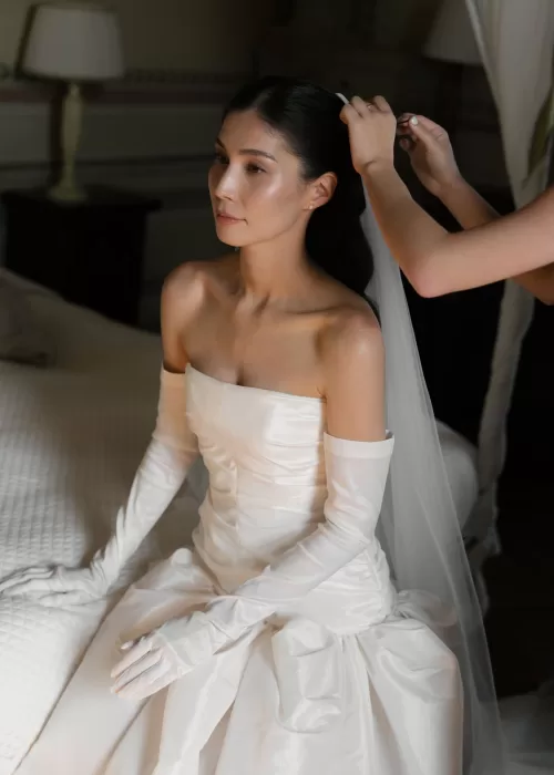 Bride sits gracefully as her veil is placed before the ceremony inside Villa Catignano.