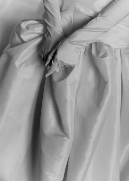 Wedding gowns hang elegantly in a painted armoire beneath an ornate ceiling at Villa Catignano.