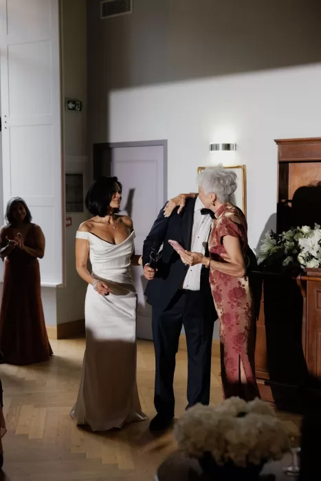 Couple celebrating with family during evening speeches inside Château de Jalesnes’ reception hall.
