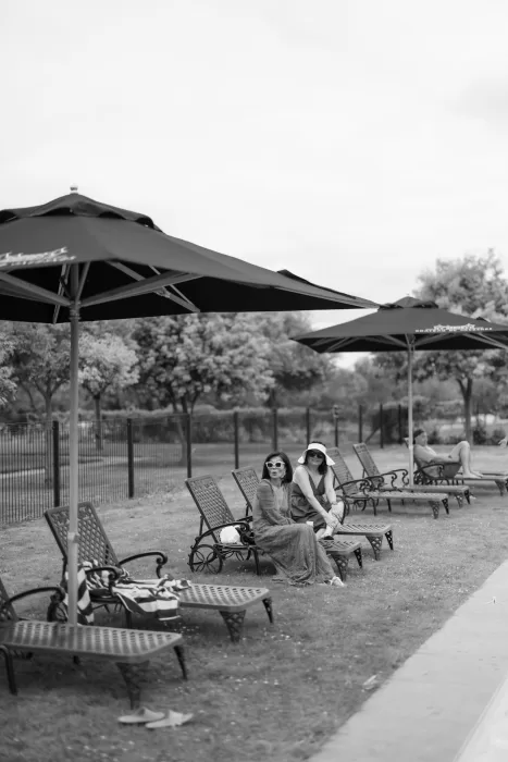 Guests relaxing under umbrellas by the pool at Château de Jalesnes during a summer wedding weekend.