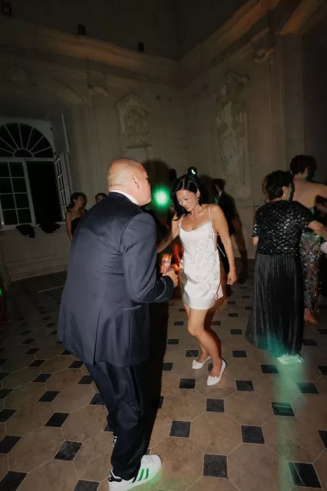 Bride and groom dancing joyfully during their evening reception inside Château de Jalesnes.