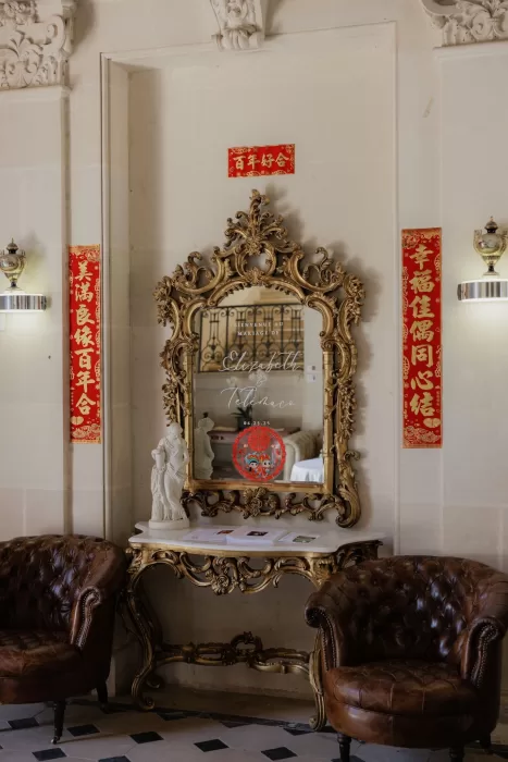 Ornate gold mirror with wedding signage and Chinese decorations at the entrance of Château de Jalesnes.