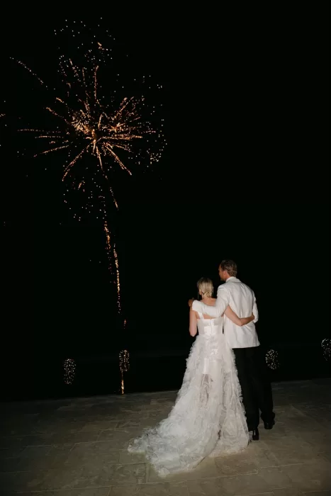Bride and groom watch golden fireworks lighting up the night sky above Dimora Delle Balze.