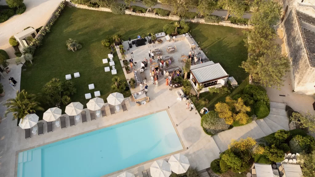 Aerial view of the pool and garden terrace filled with wedding guests at Dimora Delle Balze.