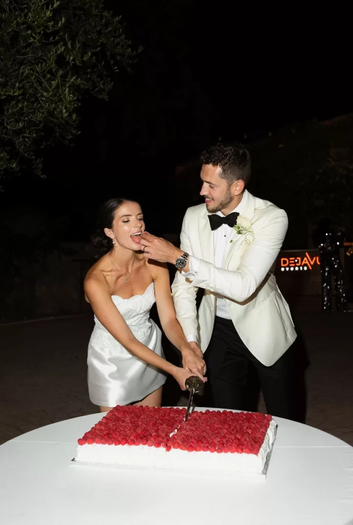 Bride and groom cutting their raspberry wedding cake at Mas del Sord during the evening celebration.