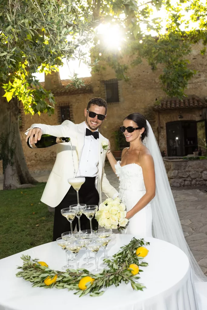 Bride and groom pouring champagne into a glass tower during their celebration at Mas del Sord.