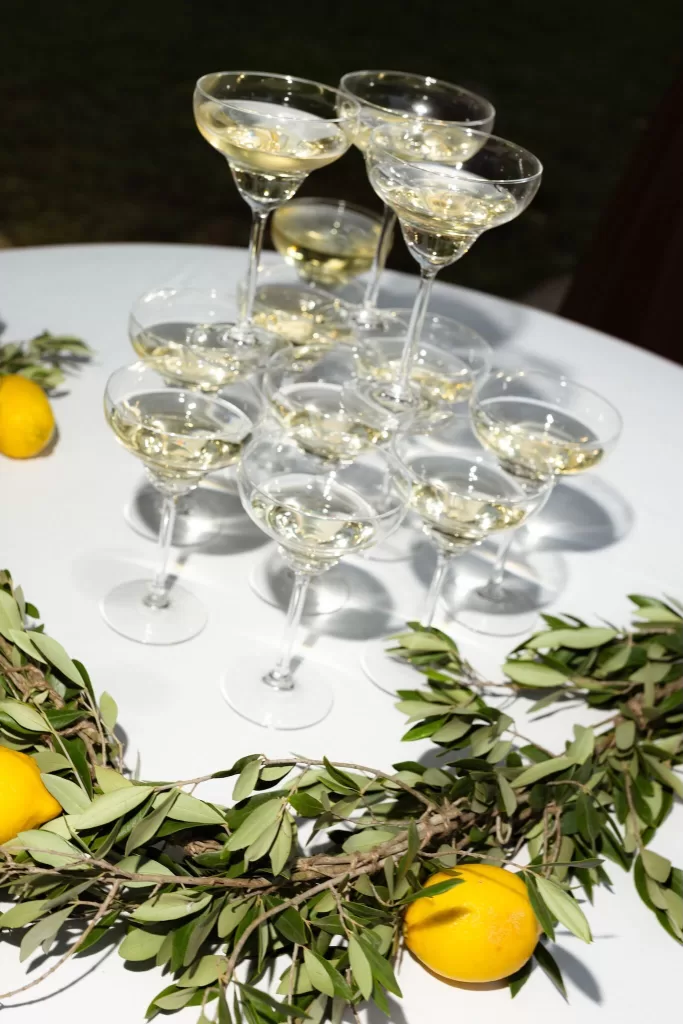 Champagne tower decorated with lemons and greenery on a white table at Mas del Sord.