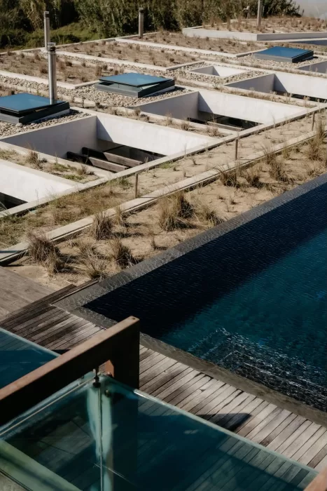 Modern architecture and outdoor pool area at Areias do Seixo, surrounded by natural textures and coastal landscaping.