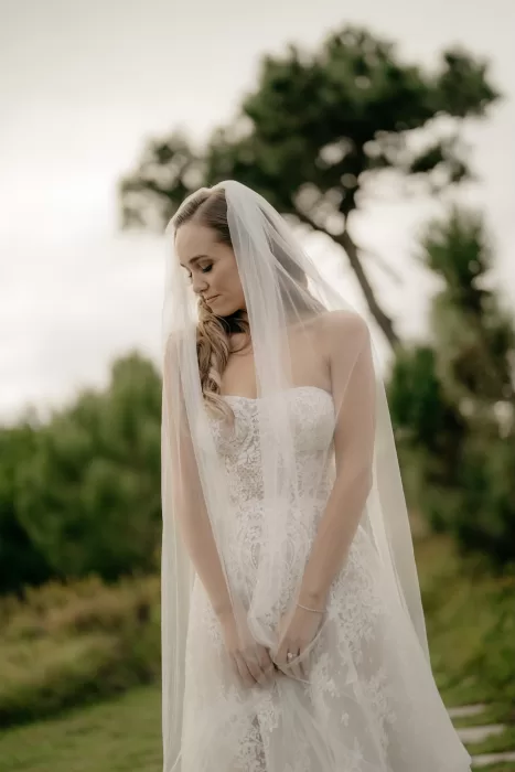 Bride standing quietly in the gardens at Areias do Seixo, her veil falling softly around her.
