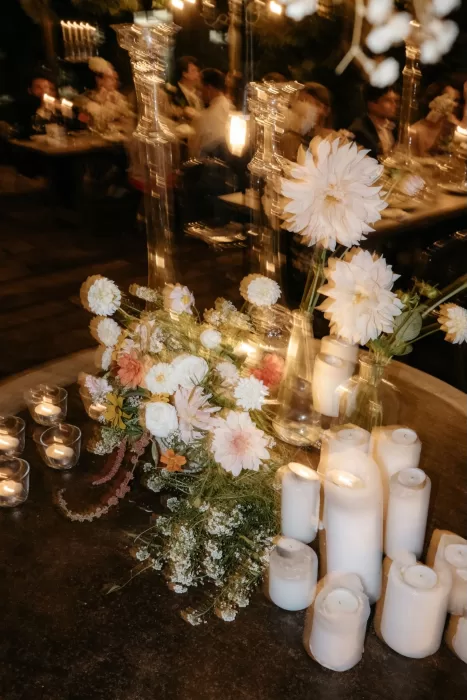 Candlelit wedding table with floral arrangements and soft lighting at Areias do Seixo, setting an intimate evening mood.