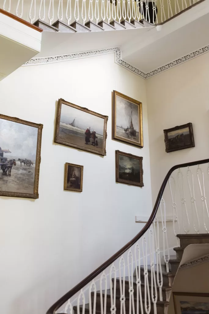 Curved staircase inside Boturich Castle with framed paintings and period architectural details.