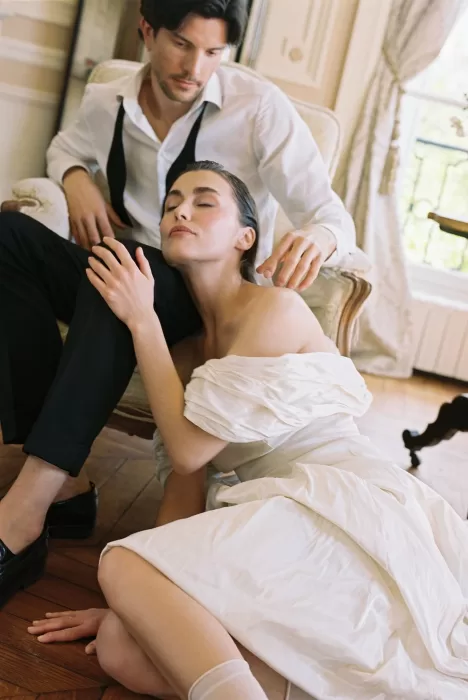 Groom resting his hand gently on the bride’s shoulder as she closes her eyes in a serene moment at Château du Prieuré.