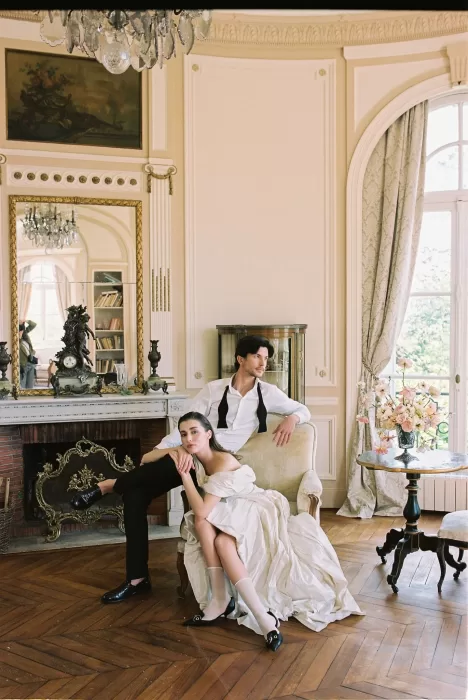 Couple posing in an elegant sitting room at Château du Prieuré, blending modern editorial style with classical French interiors.