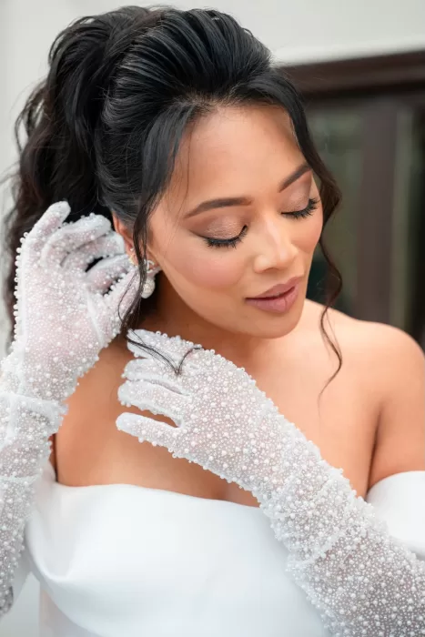 Close-up of the bride adjusting her pearl-embellished gloves during morning preparations at Jnane Tamsna.