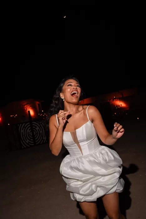 Bride laughing and dancing under the night sky during celebrations at Jnane Tamsna.