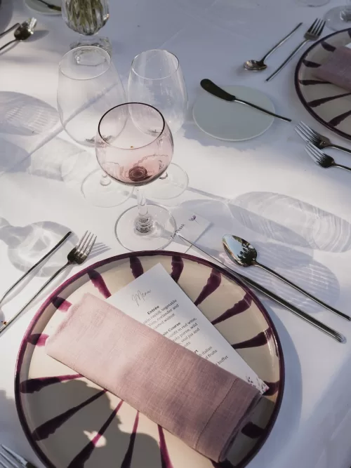 Refined wedding table setting with blush linens and glassware at Vandelli Botanical Garden.